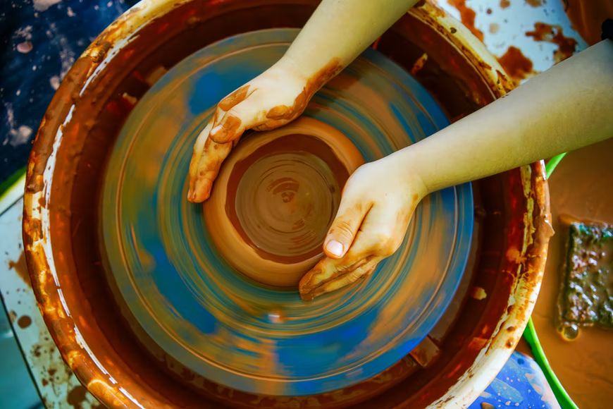 child doing pottery